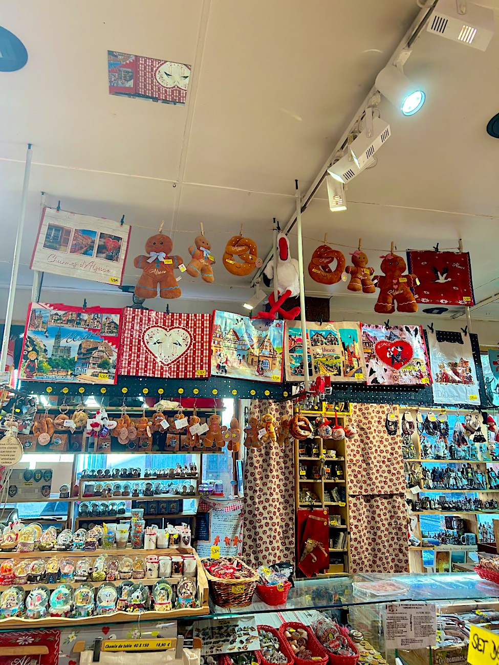 Sacs, mannele et cigognes en peluche suspendus au-dessus des boules à neige et magnets