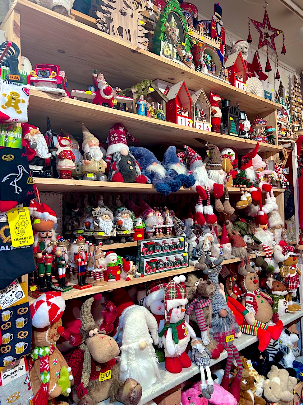 Étagères de décorations de Noël : lutins à longues jambes, pères Noël, casse-noisette et maisons lumineuses